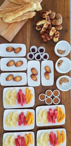 a table with plates of fruit and other foods at Pousada Villages Boutique Hotel - 150m da Praia da Laje in Pôrto de Pedras