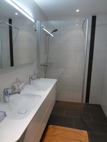 a bathroom with two sinks and a shower at Chesa La Furia in Pontresina