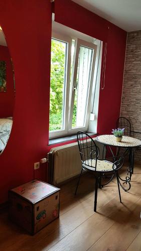 a room with a table and a chair and a window at B&B Au Jardin Fleuri in Marche-en-Famenne