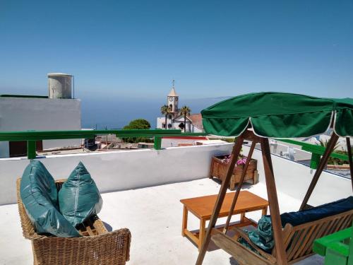 a green umbrella sitting on top of a roof at I MITI ViviendaVacacional in Chio