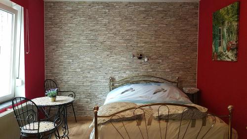 Bett in einem Zimmer mit Ziegelwand in der Unterkunft B&B Au Jardin Fleuri in Marche-en-Famenne