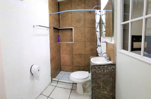 a small bathroom with a toilet and a sink at Casa con alberca climatizada privada para 8 personas in Emiliano Zapata
