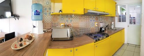 a kitchen with yellow cabinets and a counter top at Casa con alberca climatizada privada para 8 personas in Emiliano Zapata