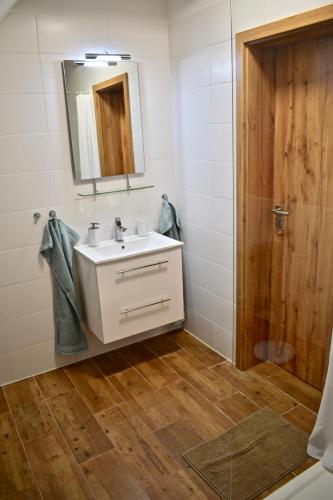 a bathroom with a white sink and a mirror at Penzion Beskydkrby in Ostravice