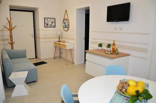 ein Wohnzimmer mit einer Küche und einem Tisch mit einer Obstschale in der Unterkunft Zenzero e Limone in Catania