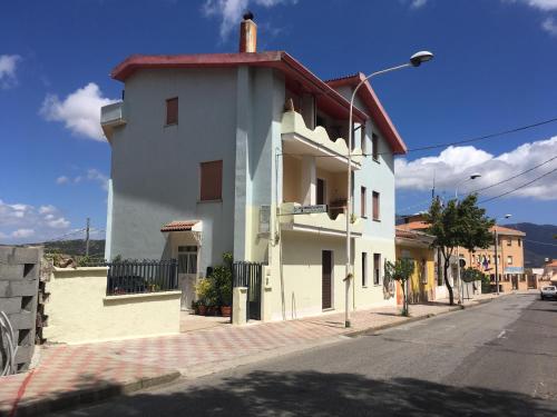 a white building on the side of a street at Bed and Breakfast da Antonio - Orgosolo in Orgosolo