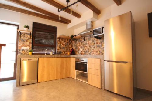 eine Küche mit einem Kühlschrank und Schränken aus Edelstahl in der Unterkunft La Rosa de los Vientos in Casas del Abad