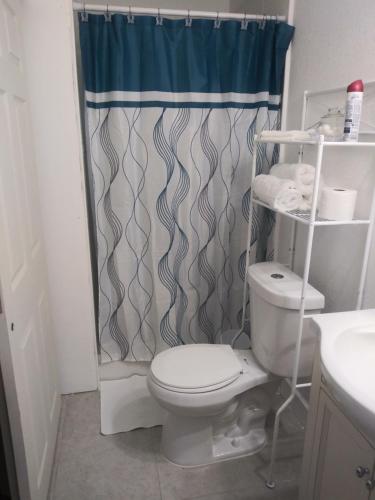 y baño con aseo y cortina de ducha. en Tampa Citrus Park, en Tampa