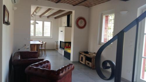 a living room with two chairs and a clock on the wall at SANTA MARIA DI LORGANA in Minerbio