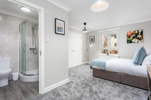 a bedroom with a bed and a shower and a toilet at Iona Residence - Donnini Apartments in Ayr