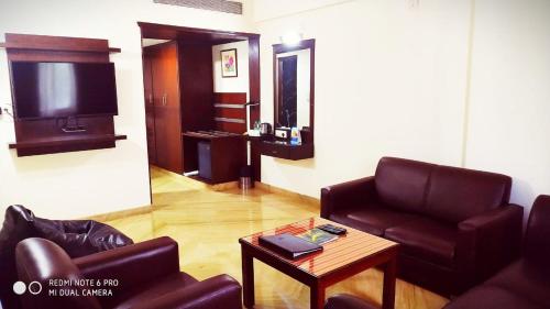a living room with a couch and a tv at The Fern Residency - Yeshwanthpur in Bengaluru