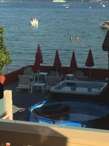 a swimming pool with chairs and people in the water at Apartments Adriatico in Herceg-Novi