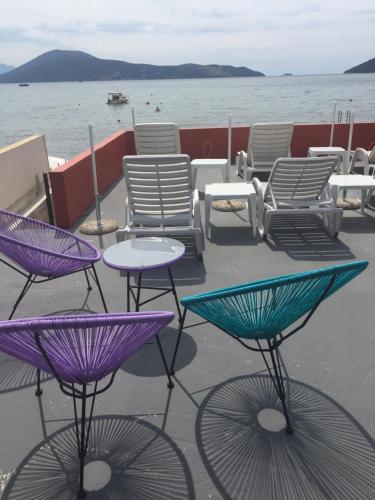 a group of chairs and tables and chairs on a boat at Apartments Adriatico in Herceg-Novi