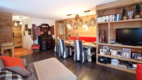 a living room with a table with chairs and a television at chesa la posta in Samedan