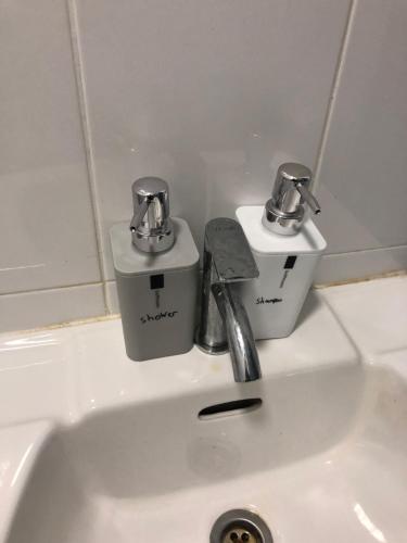 a bathroom sink with two faucets on top of it at Medina Homestay, Wakaf Che Yeh in Kota Bharu