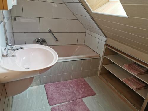 a bathroom with a sink and a bath tub at Ferienwohnung am Thayatalradweg in Schwarzenau