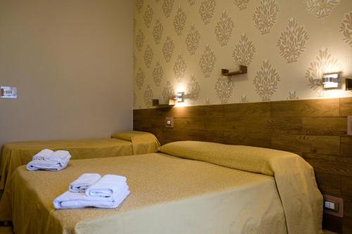 Dos camas en una habitación de hotel con toallas. en Bed & Breakfast Delle Palme, en Trapani