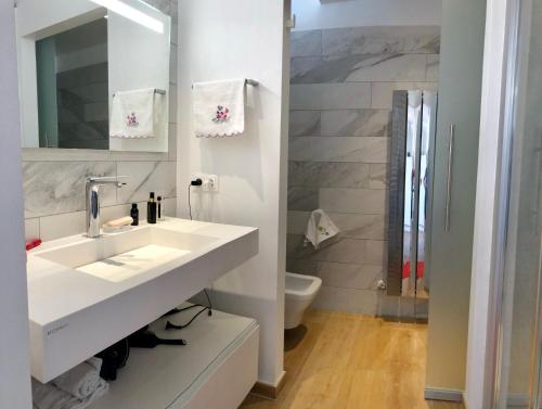 une salle de bain blanche avec un lavabo et des toilettes dans l'établissement Suite Neptune, à Nice