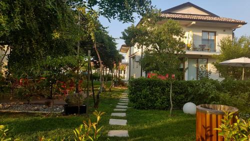 a house with a garden with a path in the yard at Apartments Aerodrom in Podgorica