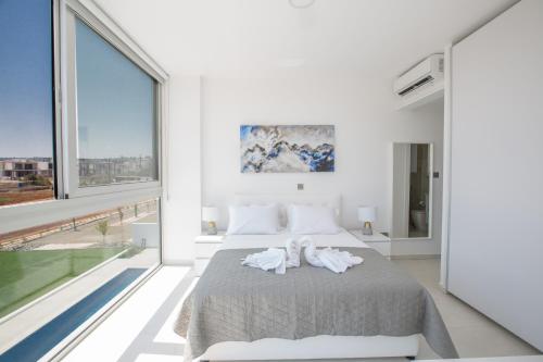 une chambre avec un lit et une grande fenêtre dans l'établissement Villa Alana, à Protaras
