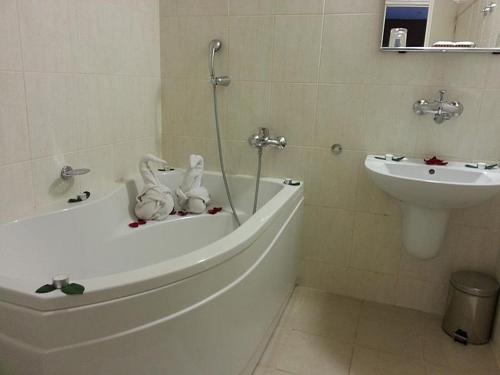a bathroom with a tub and a toilet and a sink at Wellness Hotel Staré Město in Uherské Hradiště