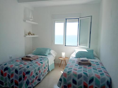 Un dormitorio con dos camas y una ventana. en Beach front line luxury apartment, 2 bedroom, en El Campello