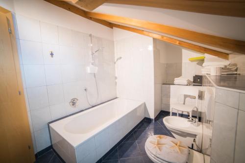 a bathroom with a white tub and a toilet at Lochererhof in Appiano sulla Strada del Vino