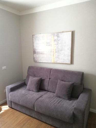 a couch in a living room with a painting on the wall at Bixio Suites in La Spezia