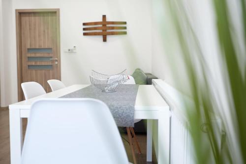 a dining room with a table and white chairs at Főtér apartman II. in Villány