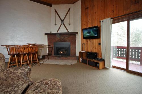 a living room with a fireplace and a tv at Spacious Townhouse Great for large groups family Snow Flake in Killington