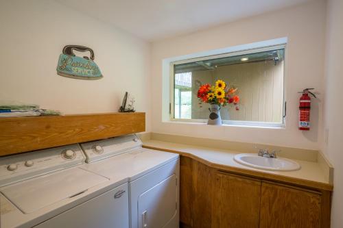 baño con lavabo, ventana y jarrón de flores en Distinctive 4 bedroom townhouse, with outdoor hot tub minutes from the slopes Winterberry 4, en Killington