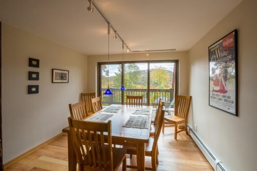 uma sala de jantar com uma mesa e cadeiras de madeira em Distinctive 4 bedroom townhouse, with outdoor hot tub minutes from the slopes Winterberry 4 em Killington