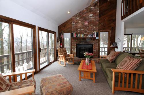 a living room with a couch and a fireplace at Three bedroom with Beautiful View & Short Walk to the Home Stretch Trail! Frosty in Killington