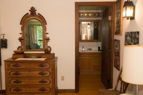 a bathroom with a dresser with a mirror on it at Perfect secluded 3 bedroom cozy getaway home Hawk Landing in Pittsfield