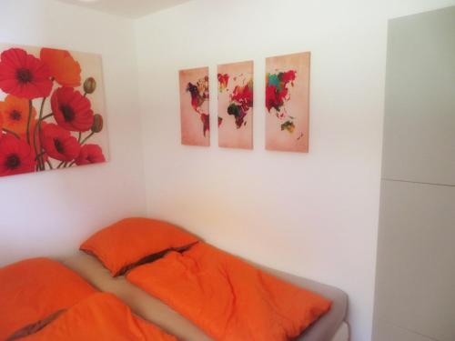 a bedroom with four paintings on the wall at Ferienwohnung - Missen-Wilhams Allgäu in Missen-Wilhams