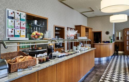 a restaurant with a counter with food on it at Dom Hotel in Osnabrück