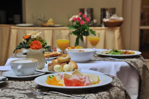 a table with plates of food and glasses of orange juice at Boutique Hotel Constans in Prague