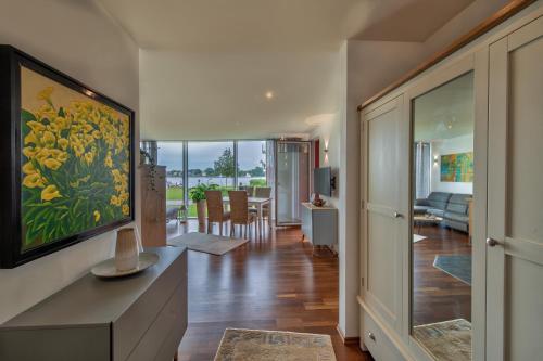 a living room with a large painting of yellow flowers at "myHarbourfront", luxuriöses Wohnen an der Hafenmole in Rostock