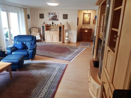 a living room with a blue chair and a tv at Ferienhaus am Rheintor in Andernach