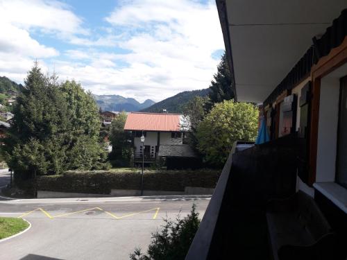 - une vue sur une rue avec un bâtiment et des montagnes dans l'établissement les rosiers n°2, aux Gets