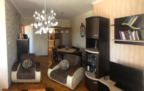 a living room with a television and a dining room at Danube duplex apartment in Smederevo