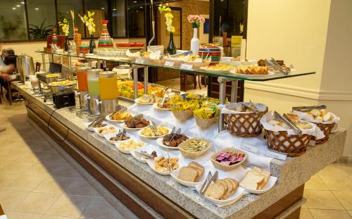 a buffet table filled with different types of food at Golden Tower Pinheiros by Fênix Hotéis in São Paulo
