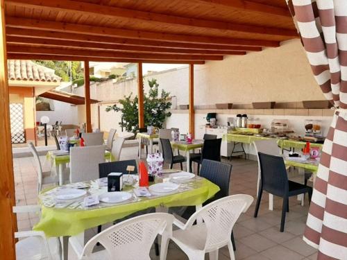 a restaurant with tables and chairs and a kitchen at B&B Villa Matari in Fontane Bianche