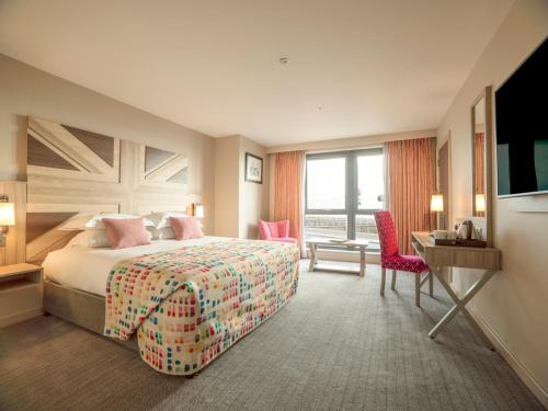 ein Hotelzimmer mit einem Bett, einem Schreibtisch und einem TV in der Unterkunft Boulevard Hotel in Blackpool