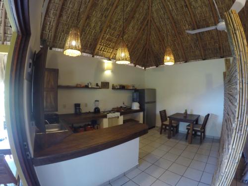 a kitchen with a counter and a table with chairs at Casa Aditi in Mazunte