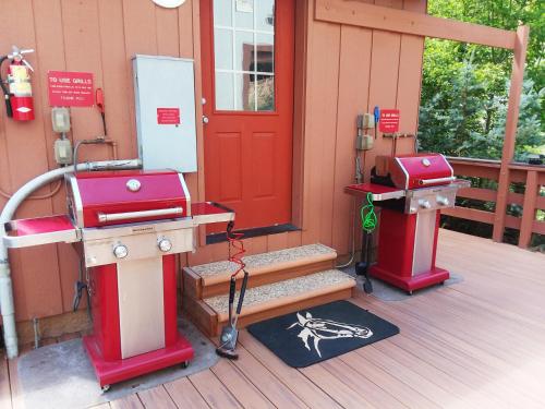 a front porch with a red door and a grill at Hot Springs Inn in Ouray