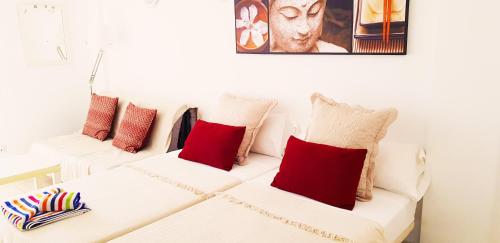 プラヤ・デ・ラス・アメリカスにあるApartment in El Dorado complexの白いソファ2台(赤い枕付)が備わる客室です。
