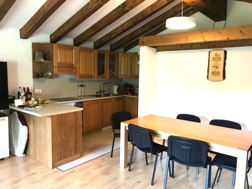 eine Küche mit einem Holztisch und schwarzen Stühlen in der Unterkunft Appartamento chalet in Laax