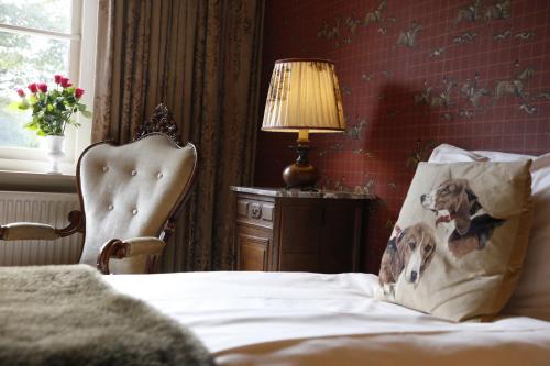 - une chambre avec un lit, une chaise et une lampe dans l'établissement Het Ros van Twente, à De Lutte