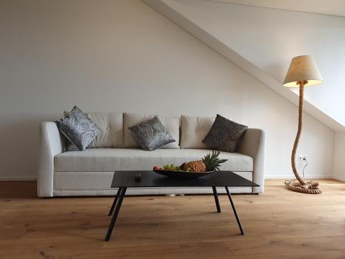 a living room with a couch with a bowl of fruit on a table at Wohnstation in Subingen